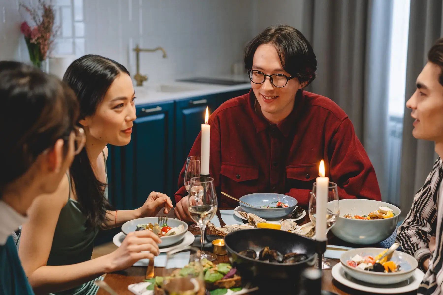 Freunde sitzen gemeinsam beim Abendessen am Tisch