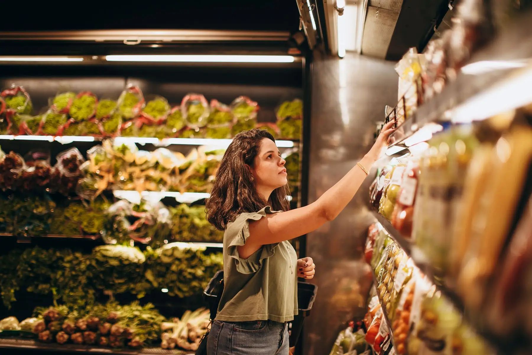 Frau wählt im Supermarkt Lebensmittel aus, die zu ihrem Alltag passen